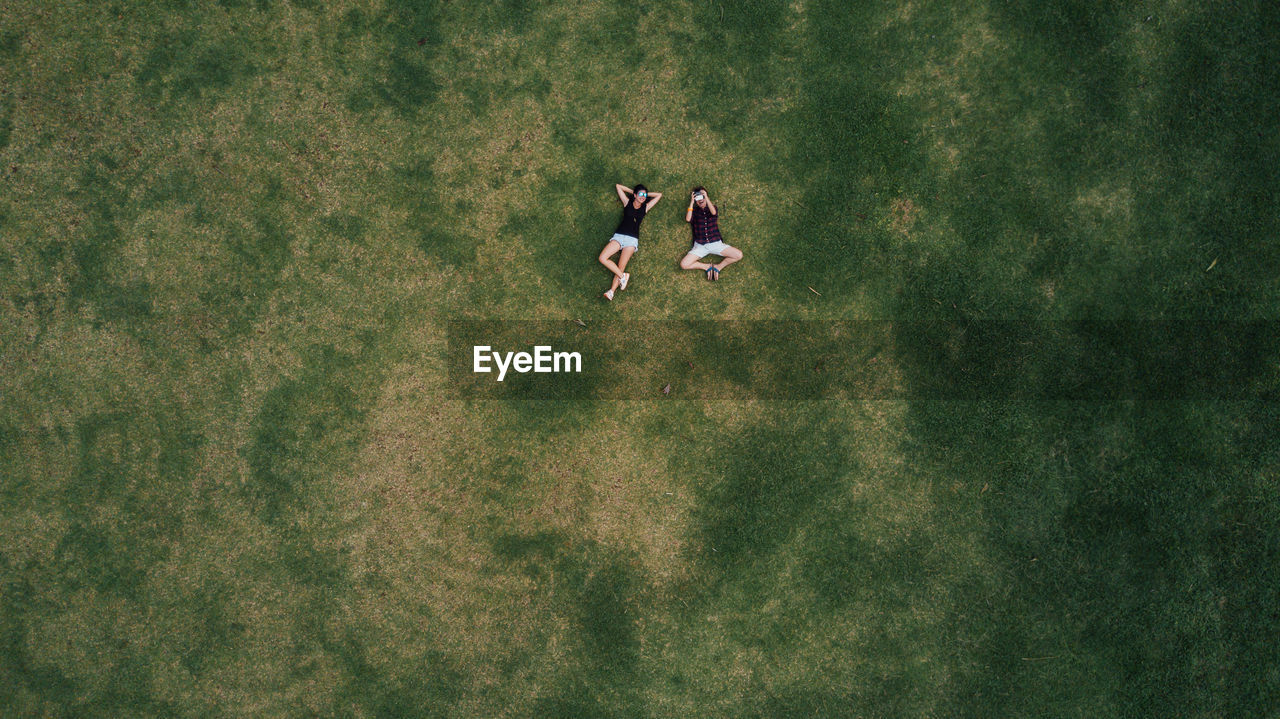 High angle view of women lying in grass