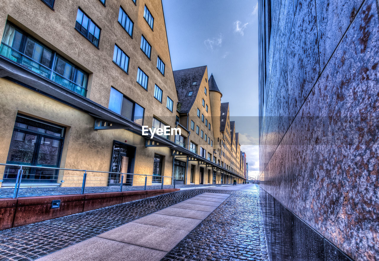 STREET AMIDST BUILDINGS AGAINST SKY