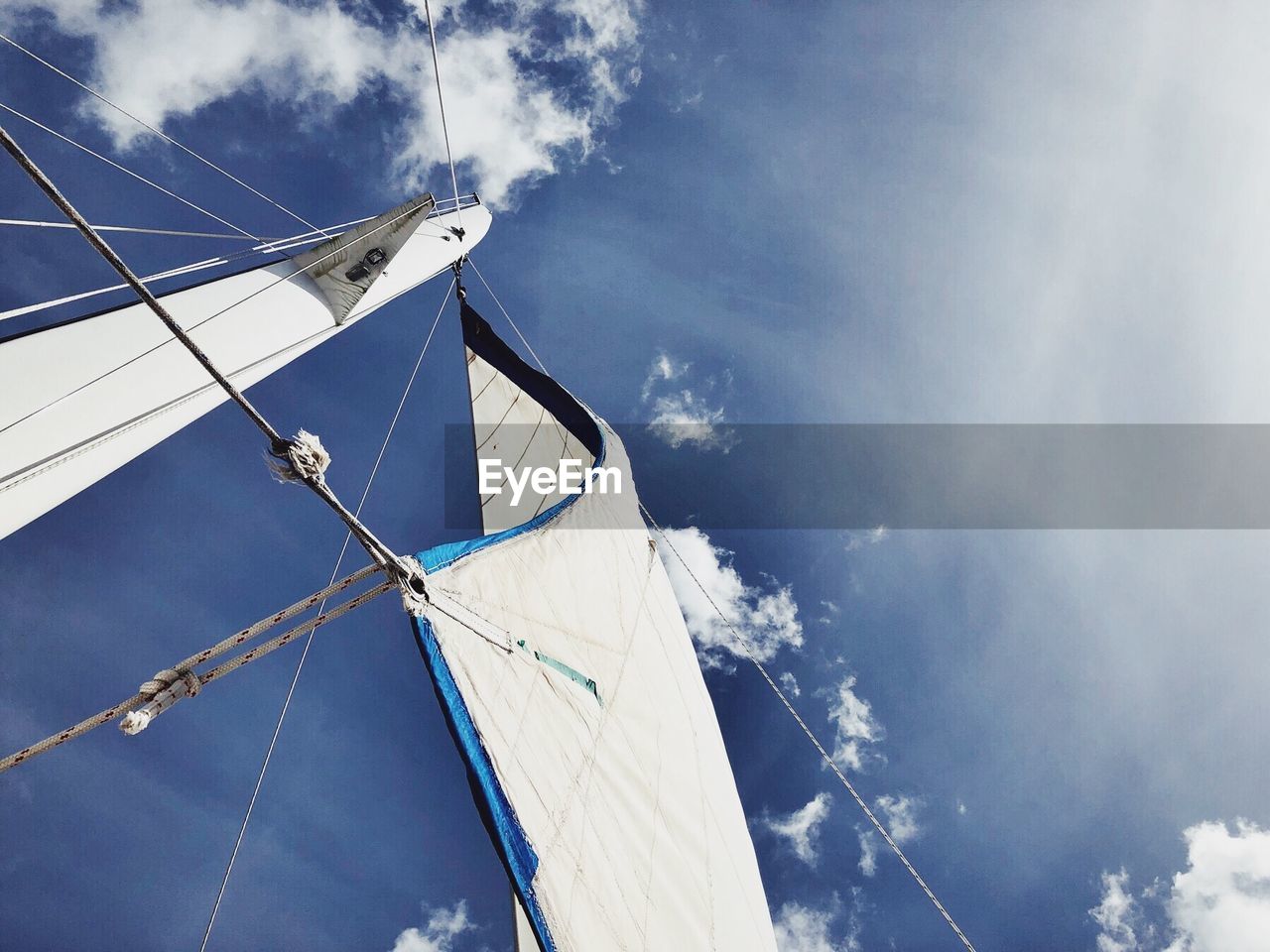 Low angle view of sailboat canvas against blue sky