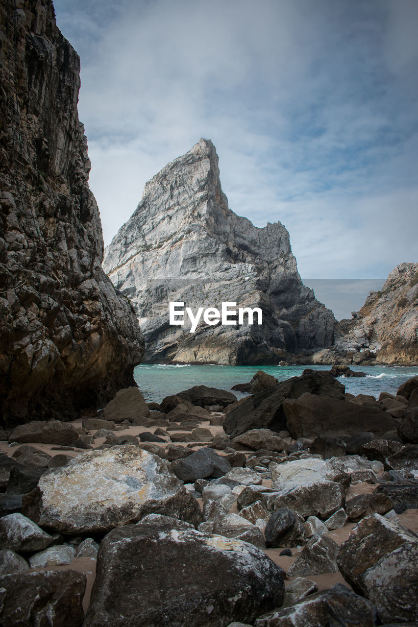 Rock formations by sea against sky