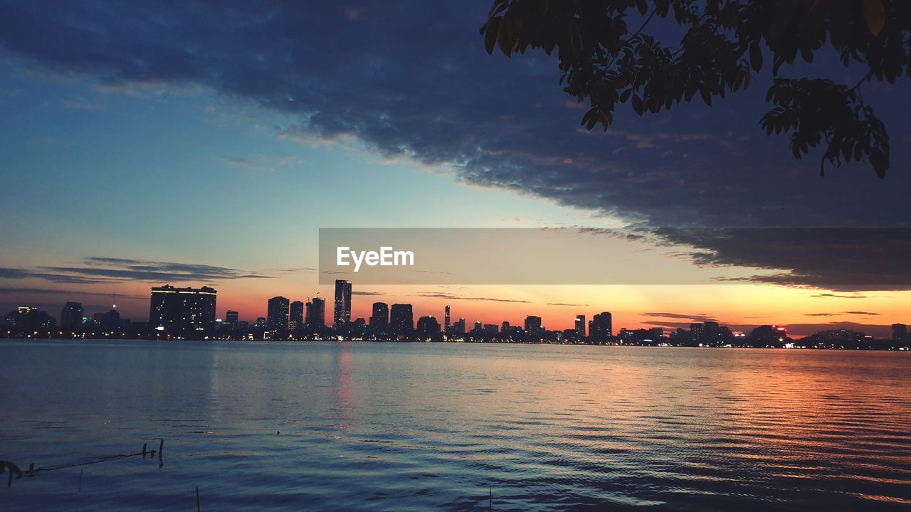 CITY BY SEA AGAINST SKY DURING SUNSET