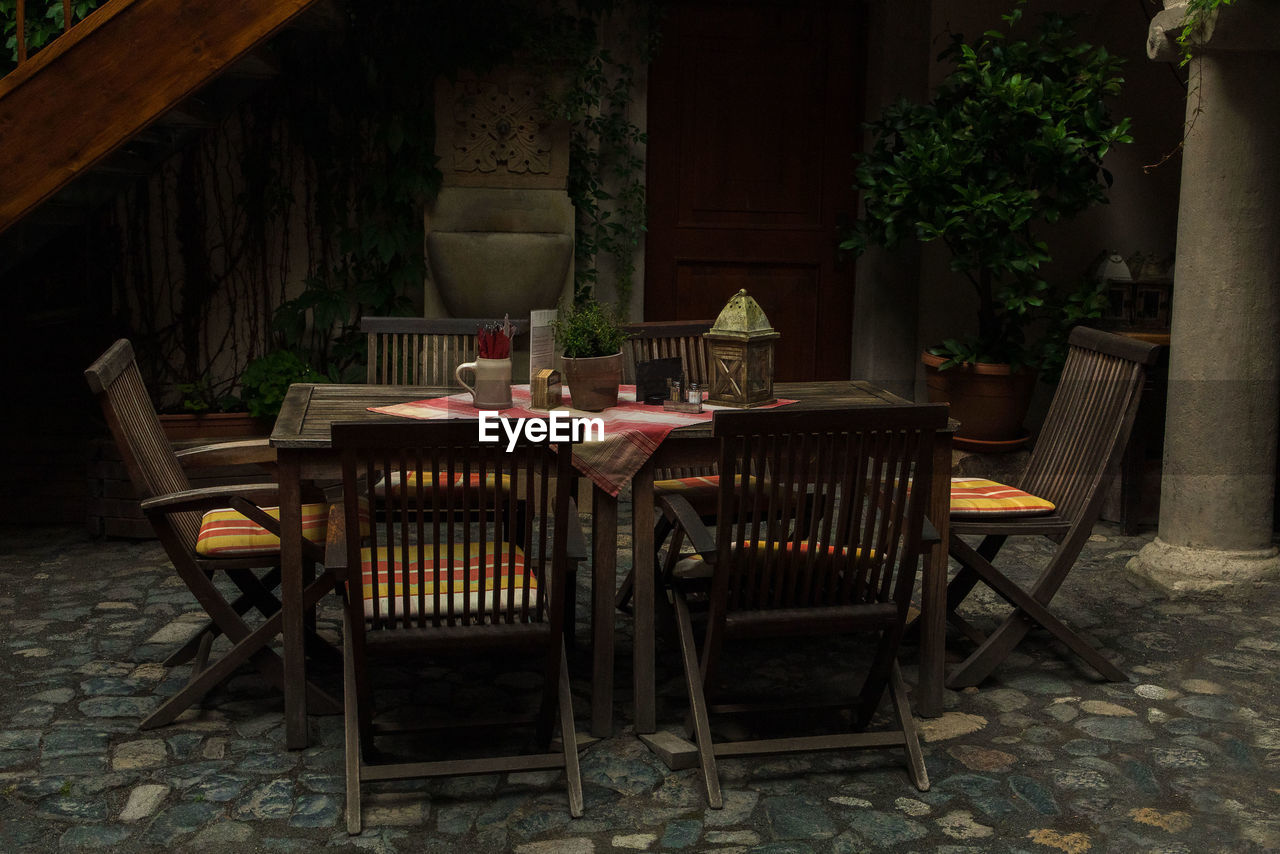 EMPTY CHAIRS AND TABLES IN RESTAURANT BY BUILDING