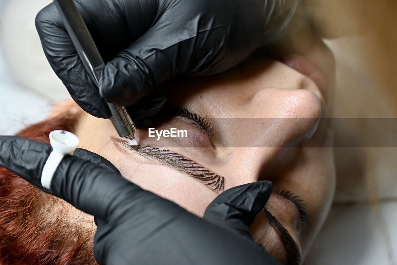 Young woman having her eyebrows micro blading 