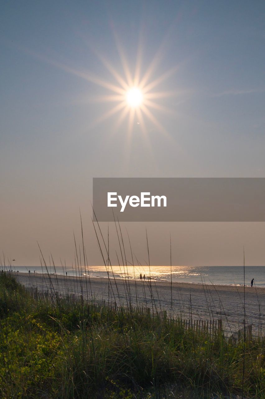 Scenic view of sea against bright sun