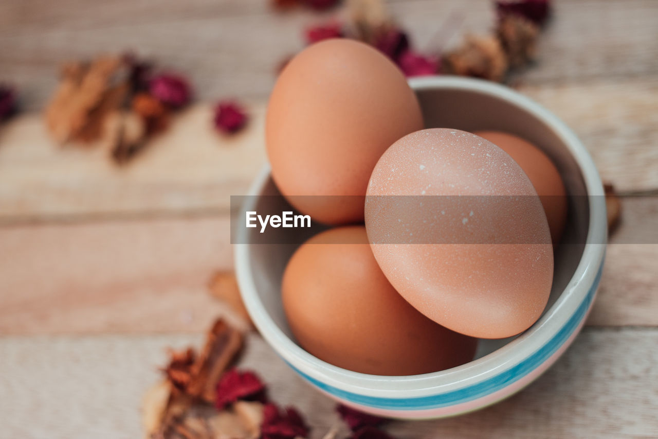 Close-up of eggs in bowl on wooden table