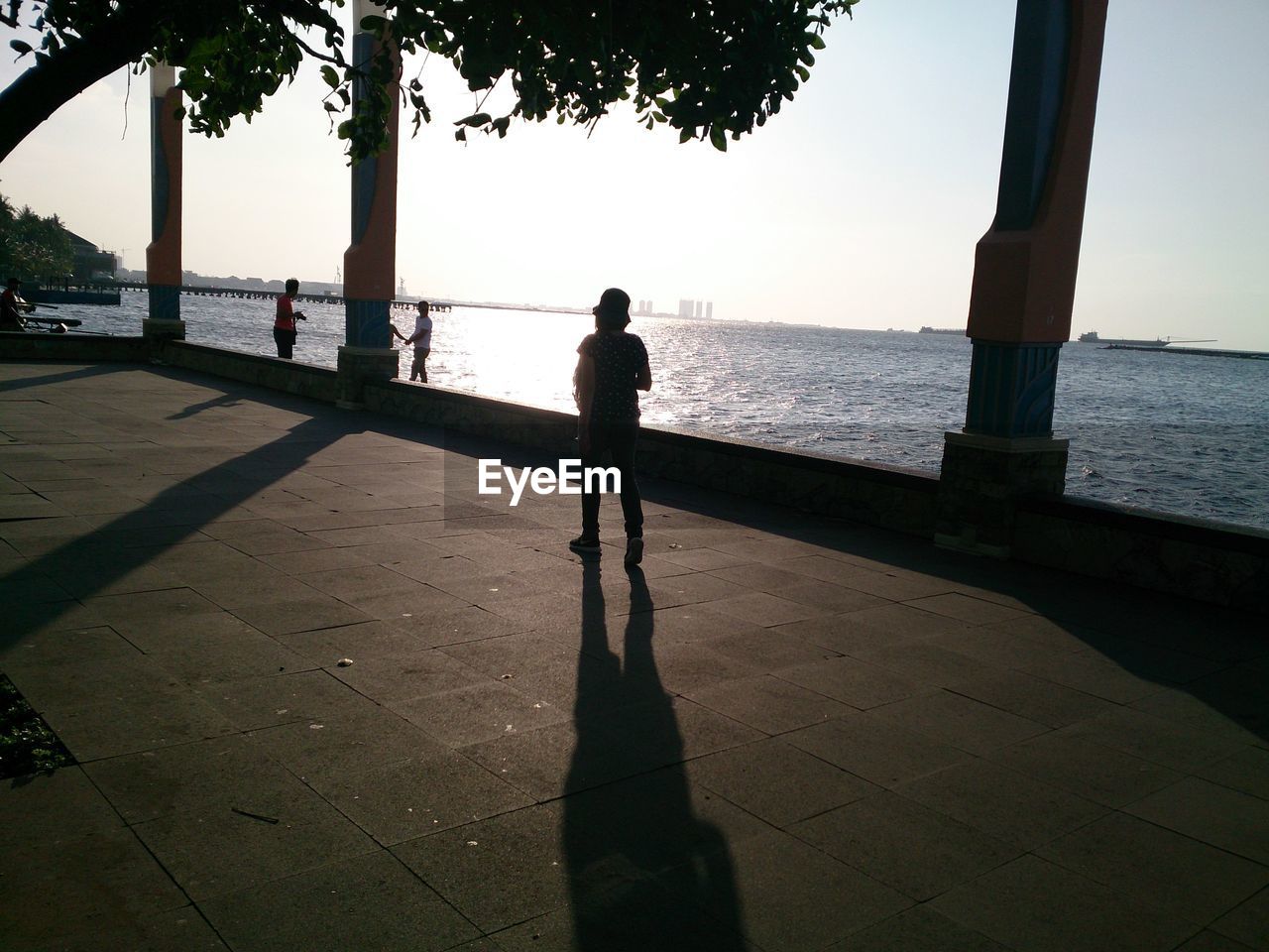 Silhouettes of pedestrians on promenade