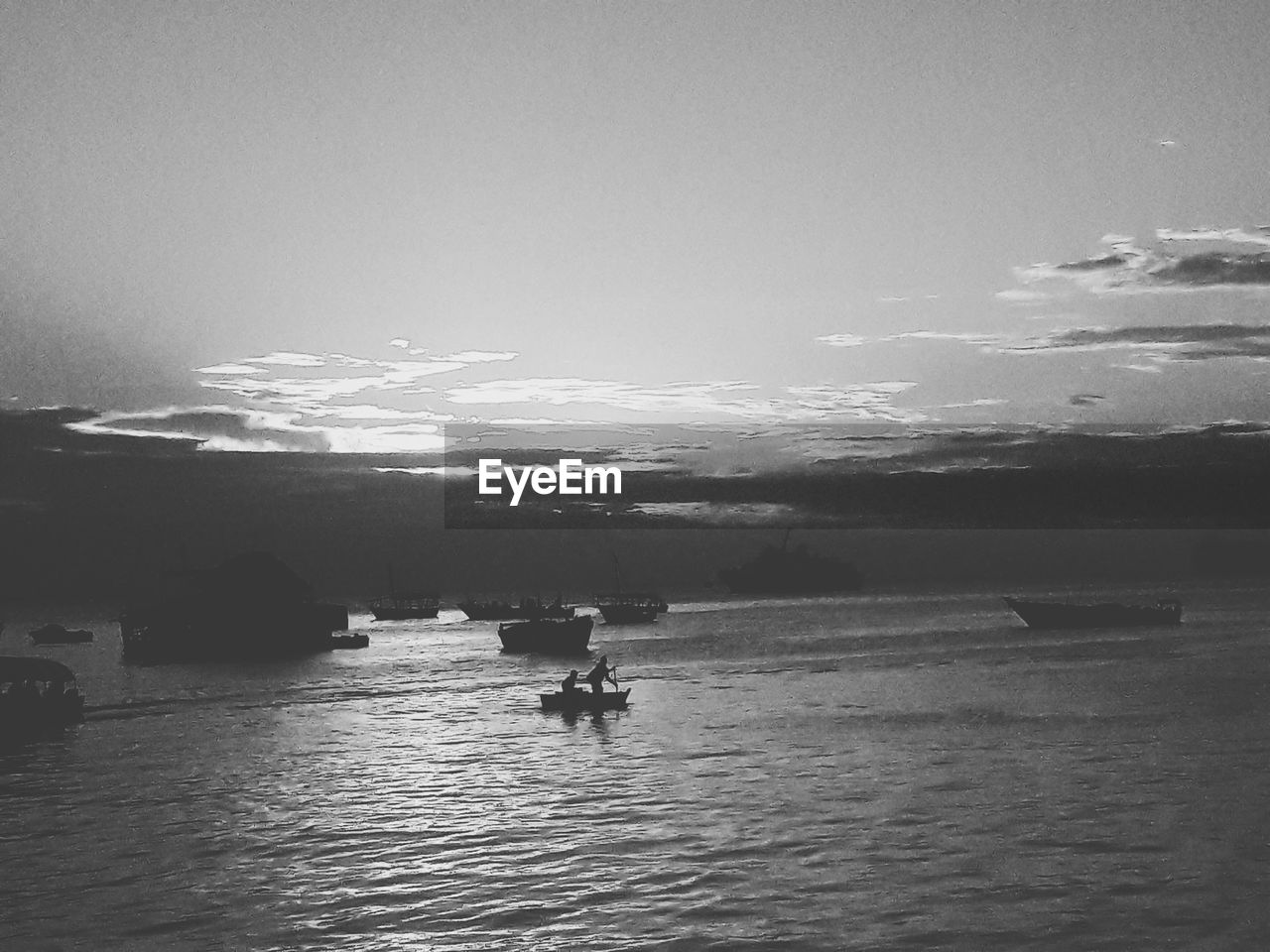 SILHOUETTE PERSON ON BOAT IN SEA AGAINST SKY