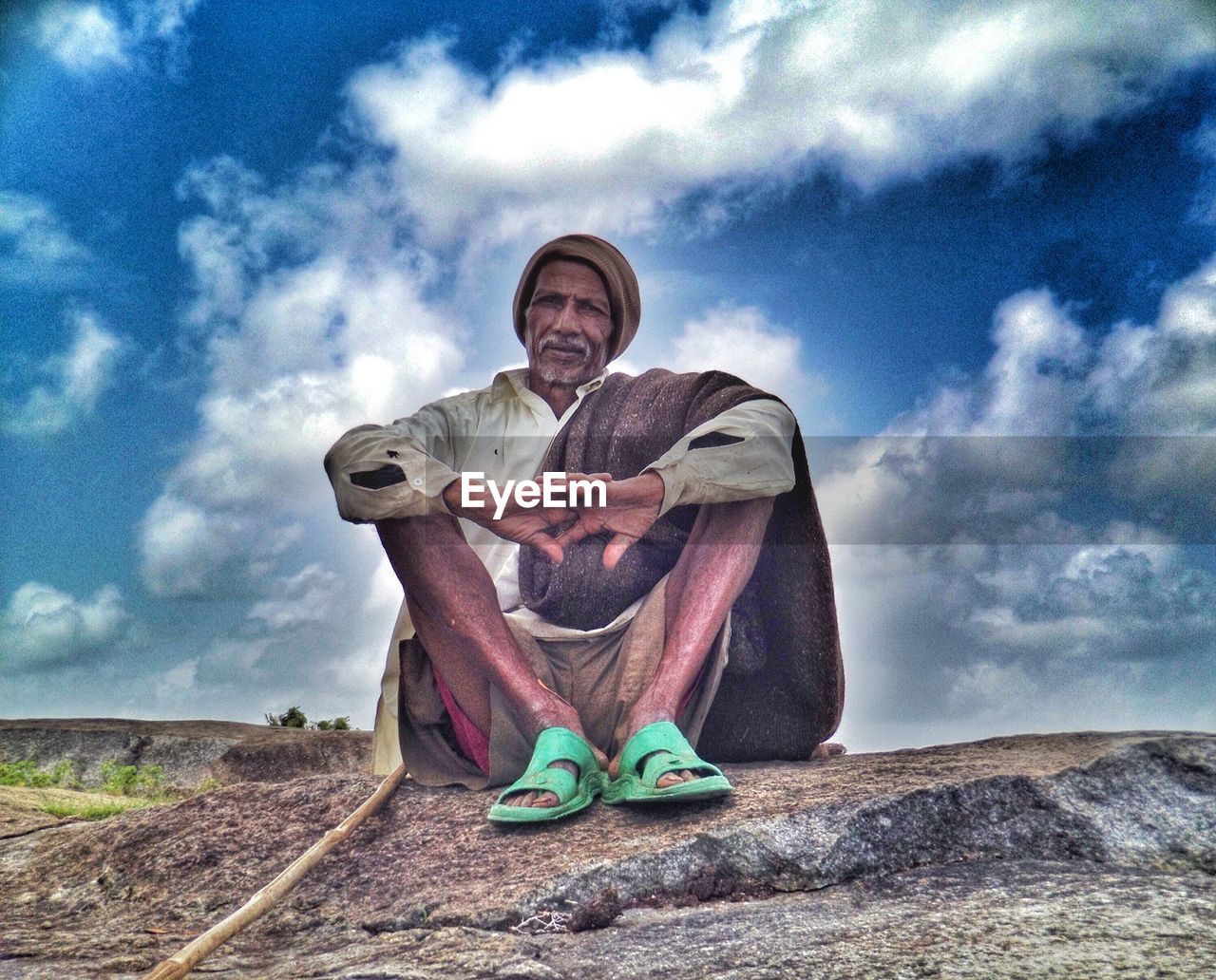 WOMAN STANDING ON ROAD AGAINST CLOUDY SKY