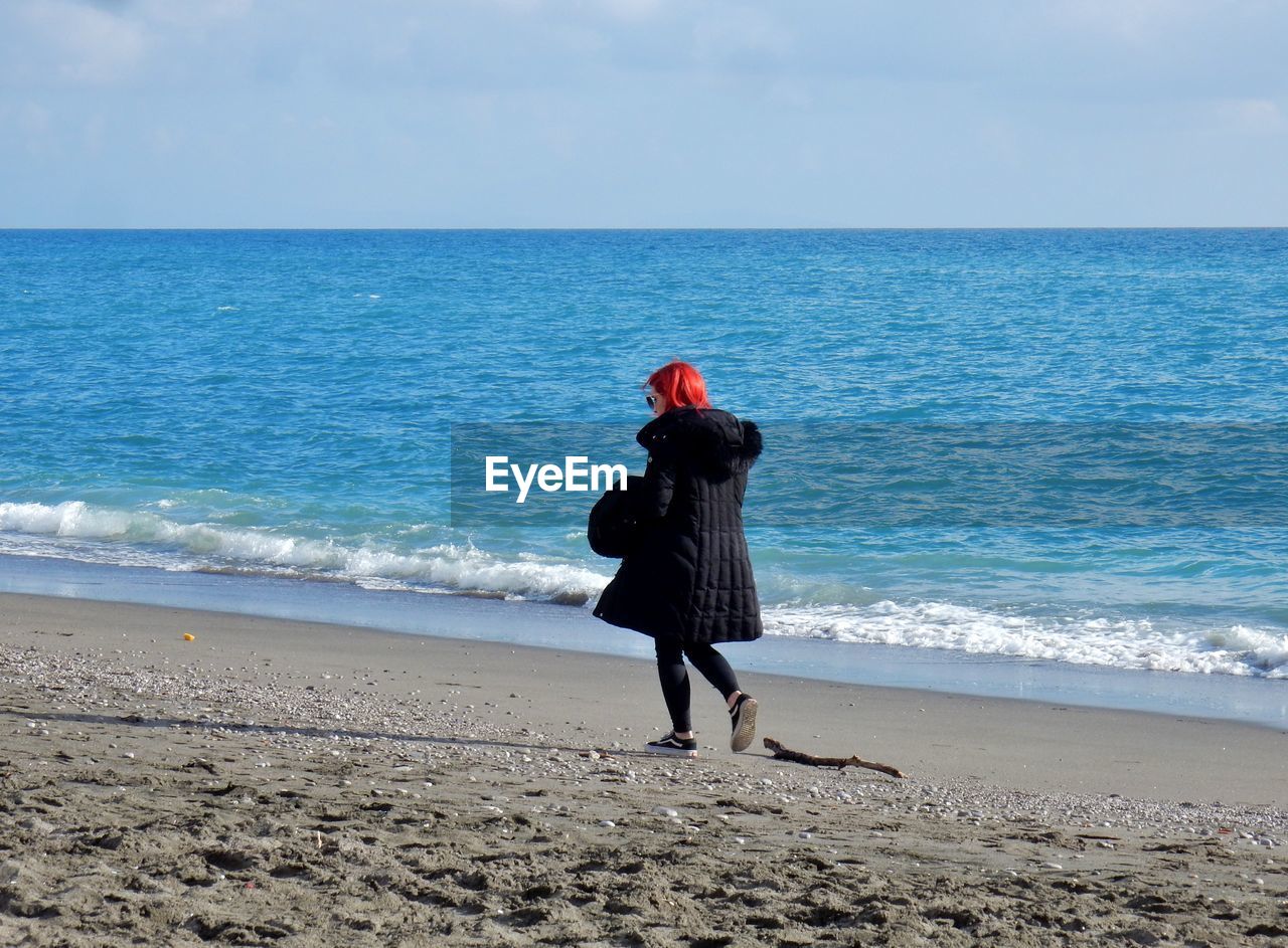 FULL LENGTH REAR VIEW OF MAN ON BEACH