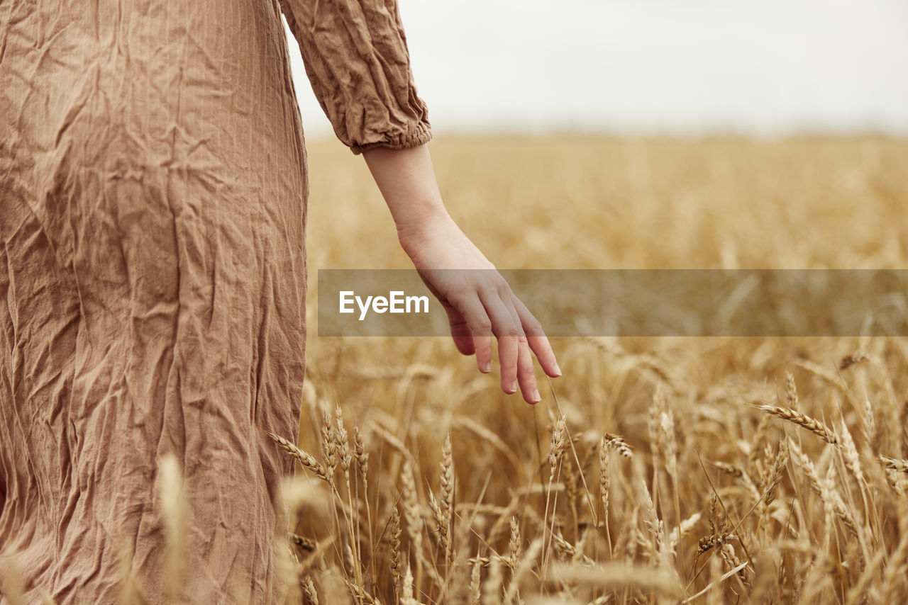 Midsection of woman standing on field