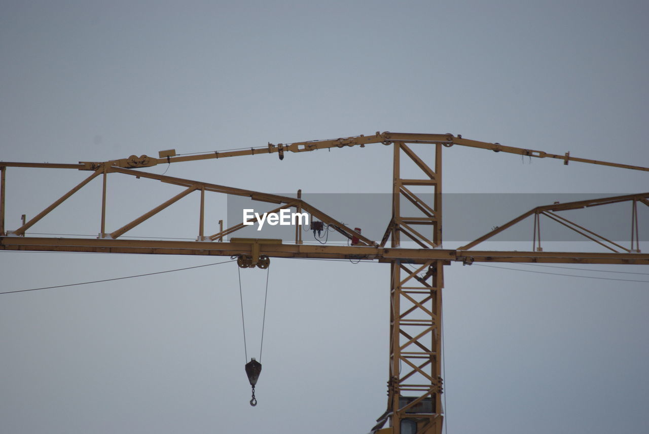 LOW ANGLE VIEW OF CRANE AGAINST BRIDGE AGAINST CLEAR SKY