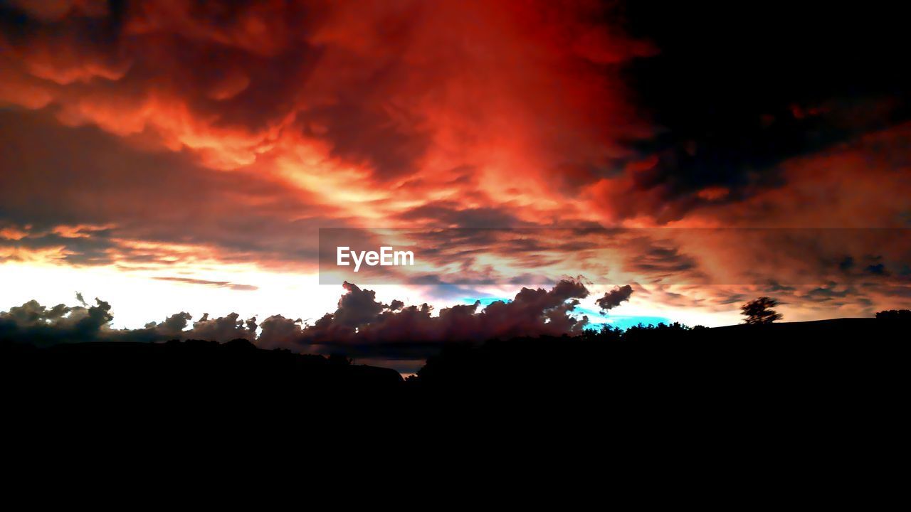 Silhouette landscape against dramatic sky