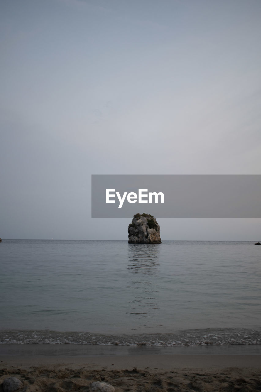 Scenic view of rocks in sea against sky