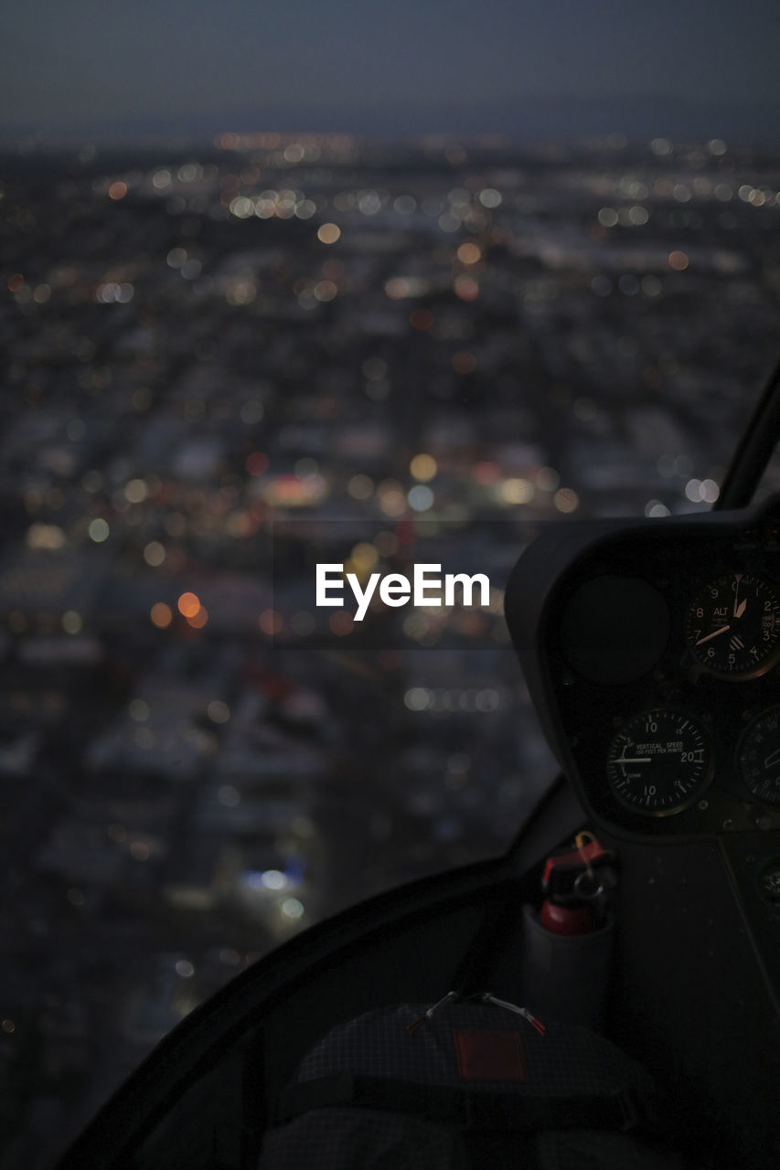 Illuminated cityscape seen through helicopter's windshield at night