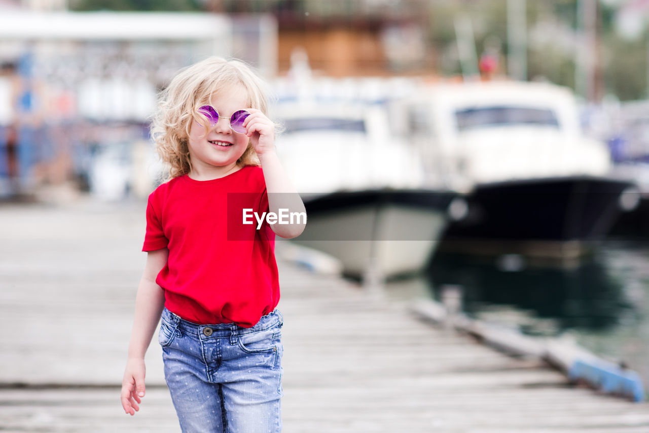 Smiling girl wearing sunglasses on jetty