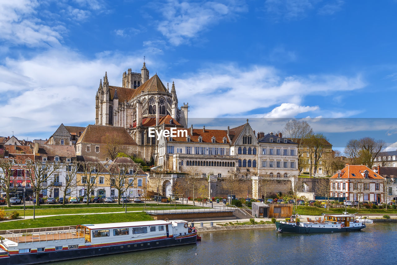 RIVER AMIDST BUILDINGS AGAINST SKY