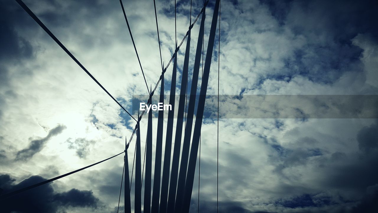 LOW ANGLE VIEW OF CABLES AGAINST CLOUDS