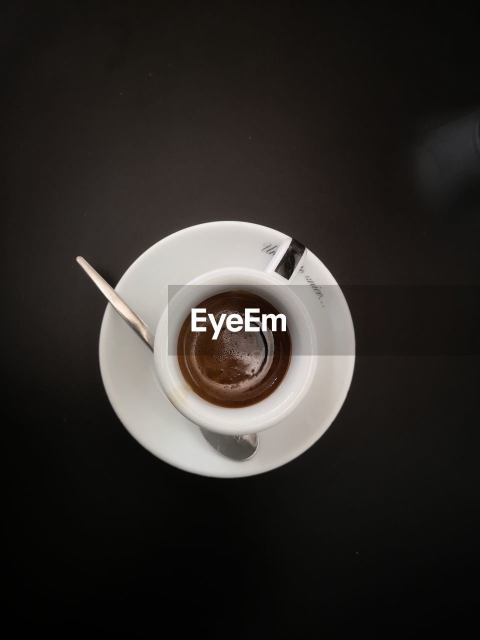 CLOSE-UP OF COFFEE CUP OVER BLACK BACKGROUND