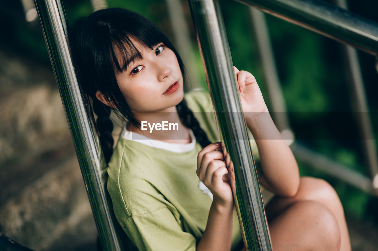 portrait of smiling young woman standing in hammock