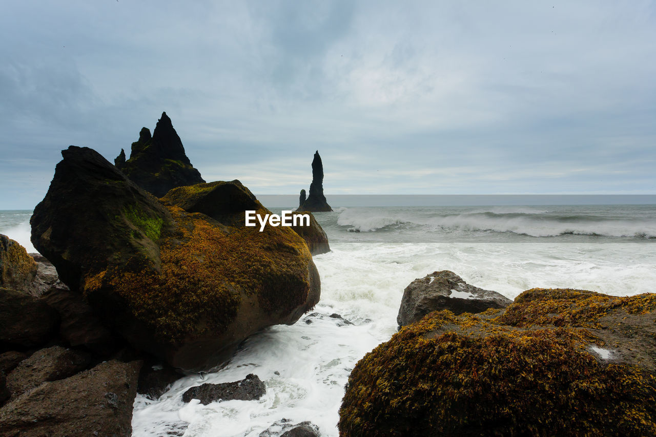 ROCKS ON SHORE AGAINST SKY