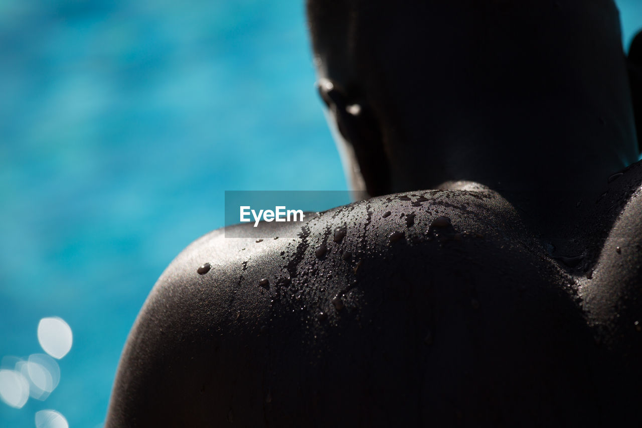 Cropped image of wet shirtless man