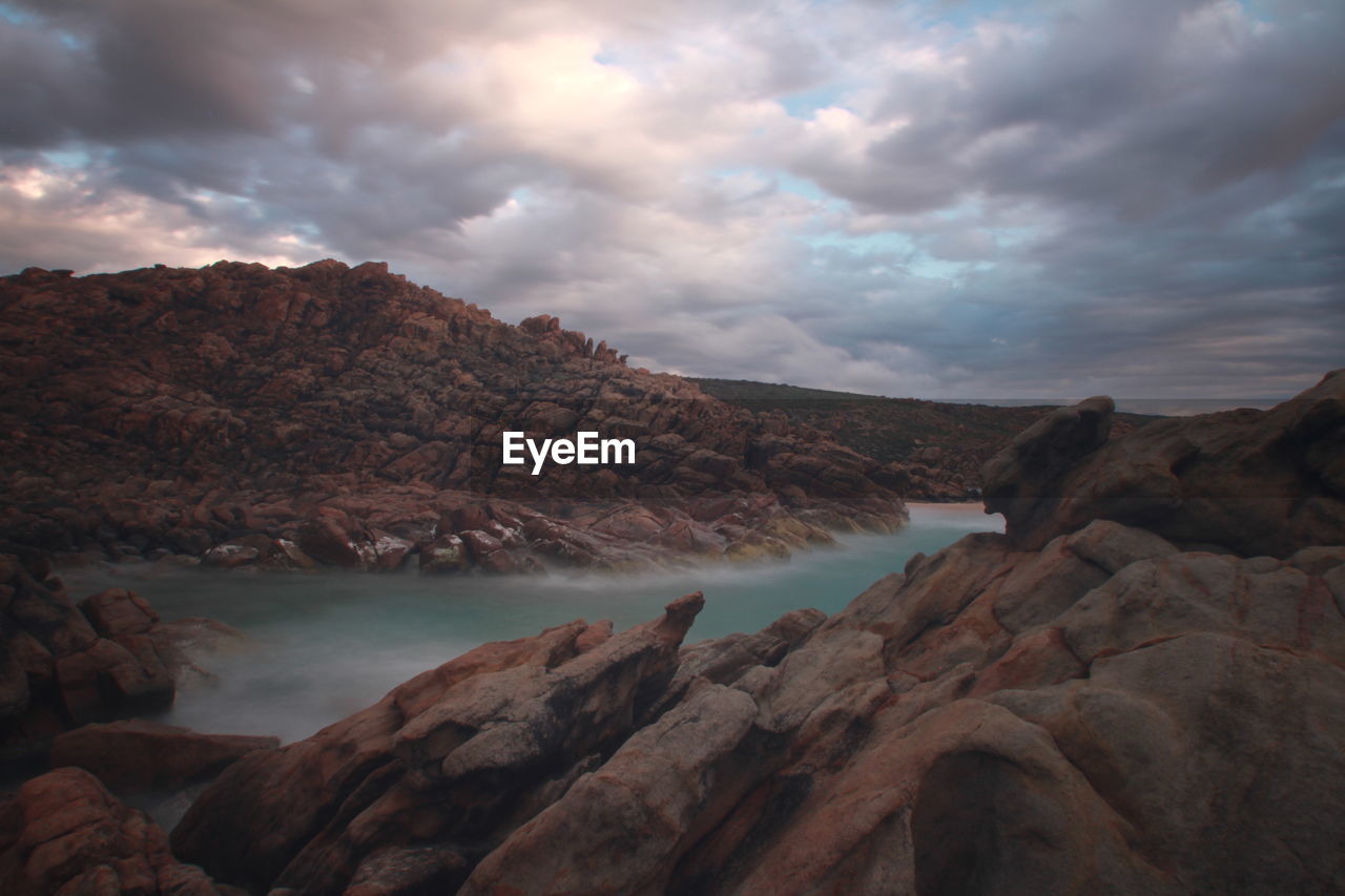 cloud, rock, sky, environment, water, nature, scenics - nature, sea, beauty in nature, landscape, land, wilderness, mountain, coast, travel destinations, travel, sunset, no people, outdoors, tranquility, dramatic sky, dawn, rock formation, geology, valley, terrain, plateau, beach, wadi