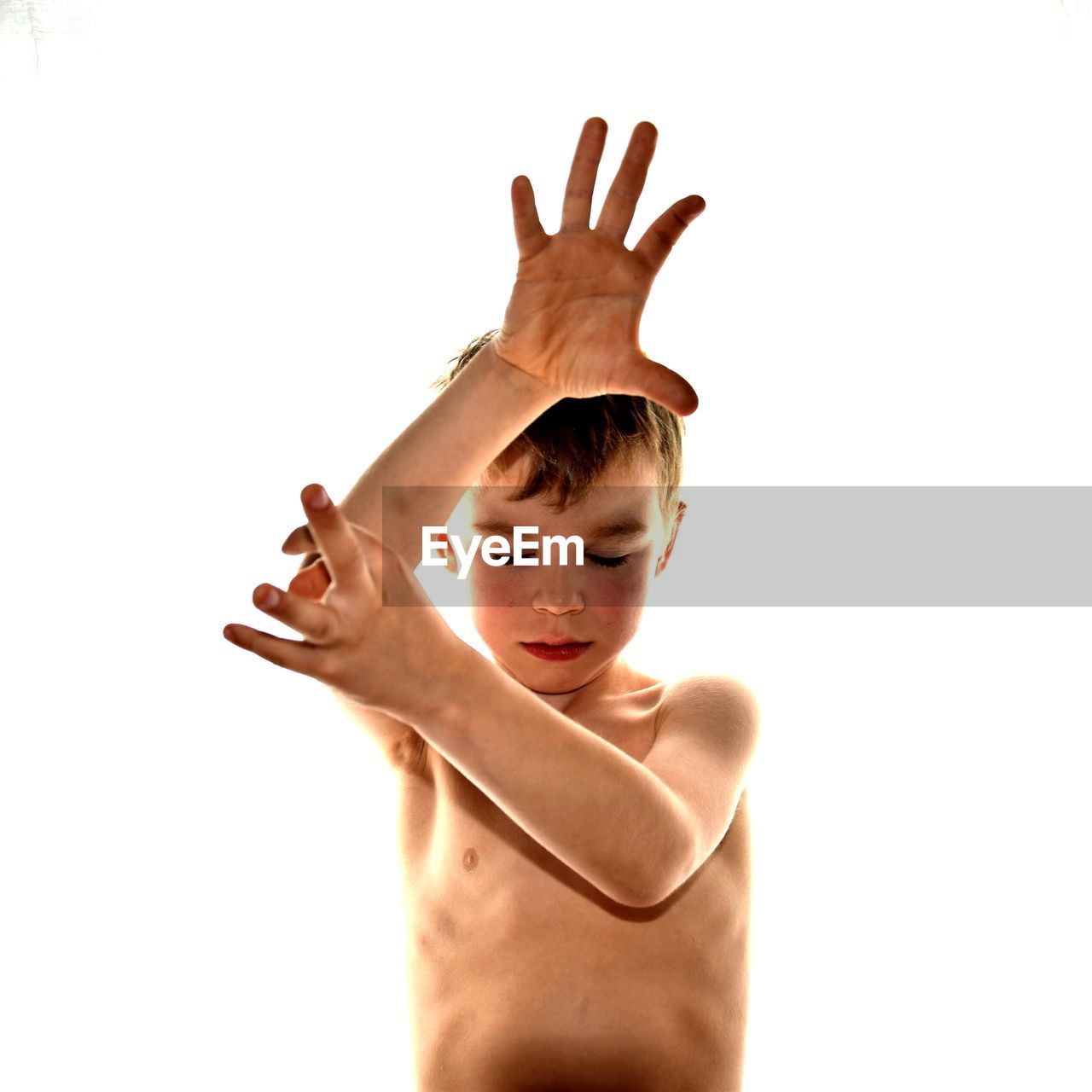 Shirtless boy gesturing against white background