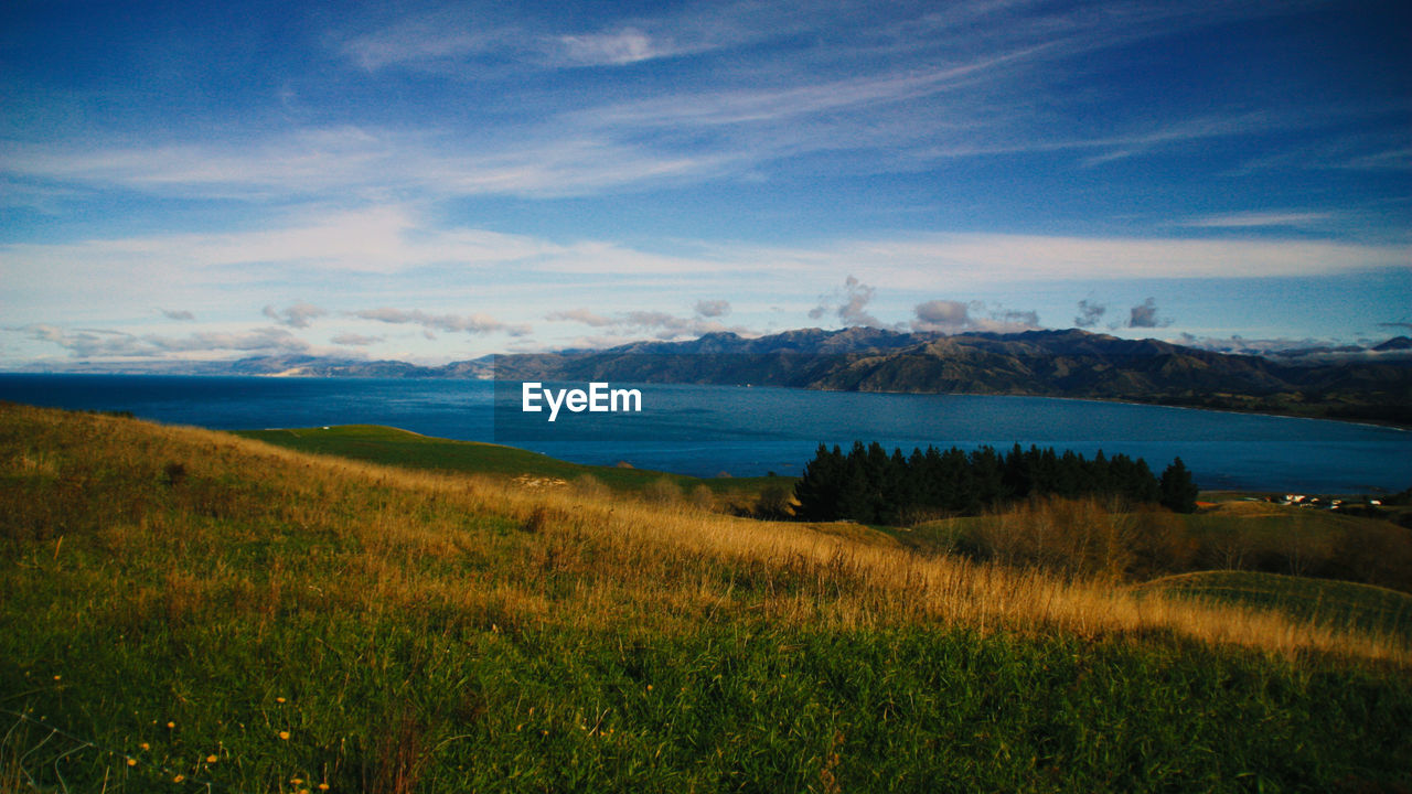 Scenic view of field and mountains against sky