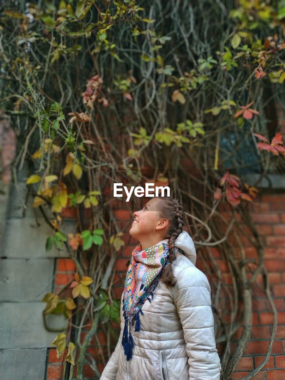 Smiling woman looking away while standing in city