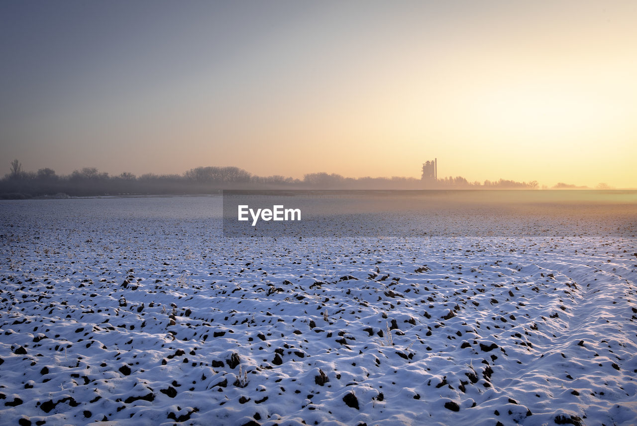 Scenic view of frozen lake against sky during sunset