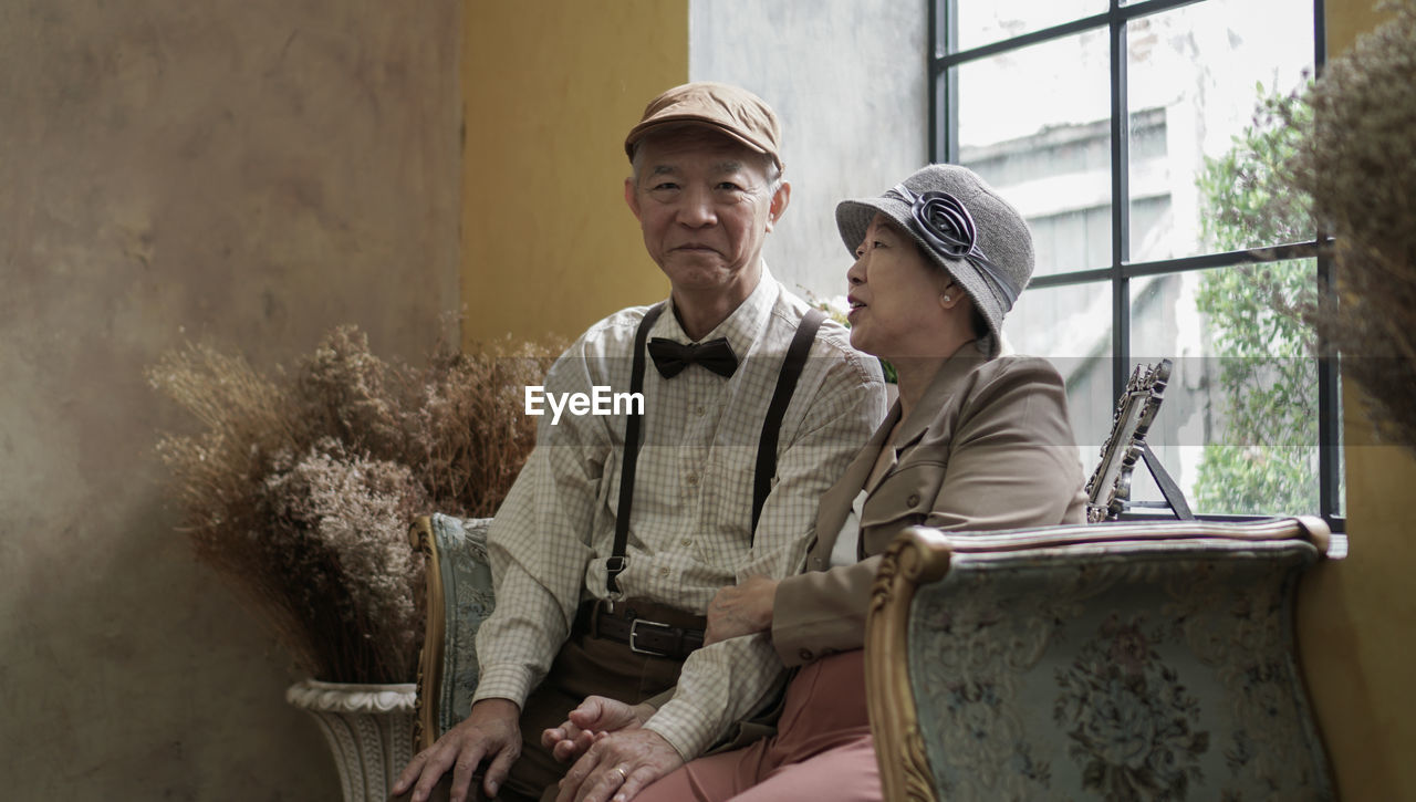 Vintage retro classic dress asian senior elder couple taking photo at luxury home together