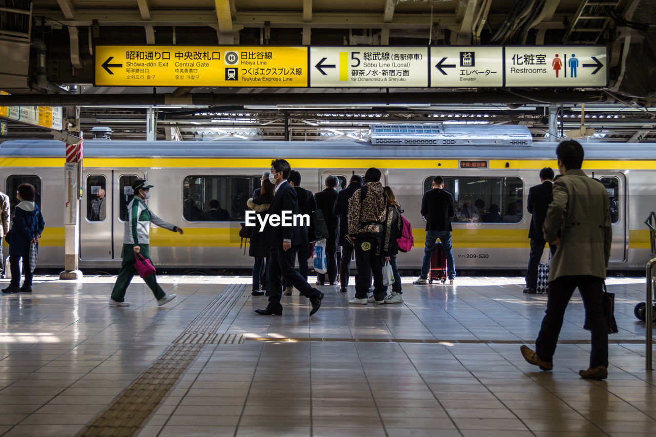 Train and people at railroad station in city