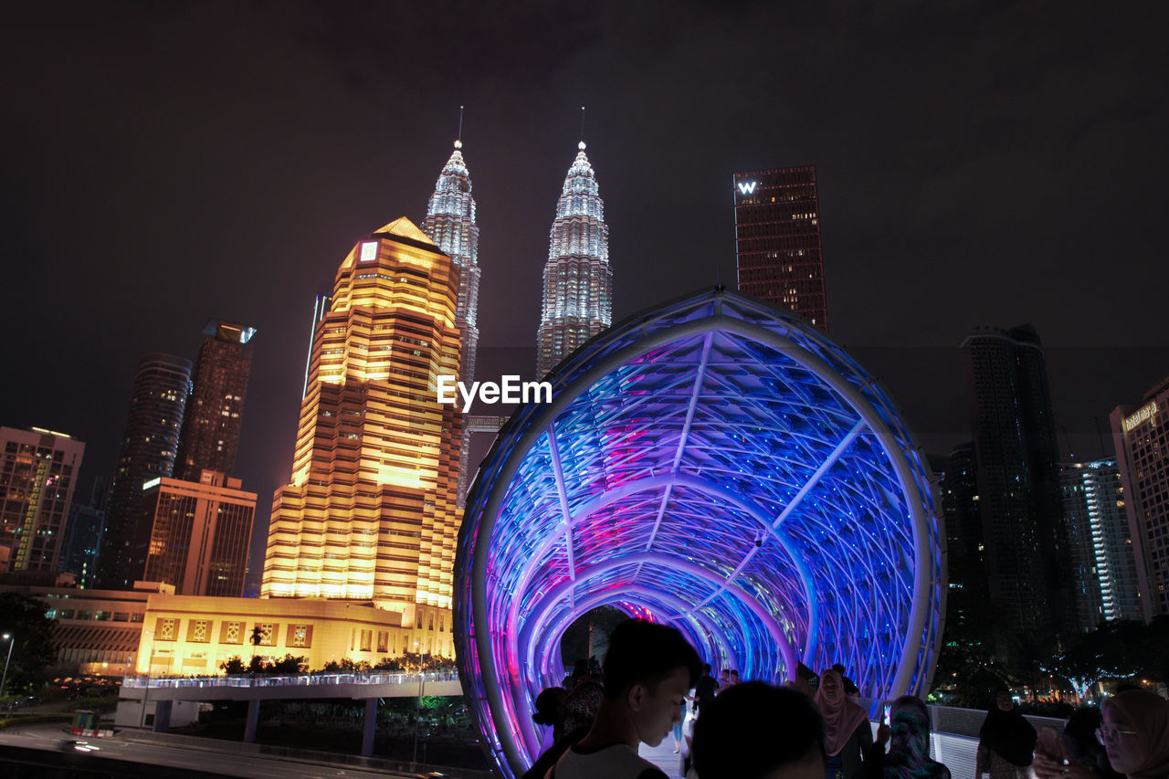 ILLUMINATED MODERN BUILDINGS IN CITY AT NIGHT