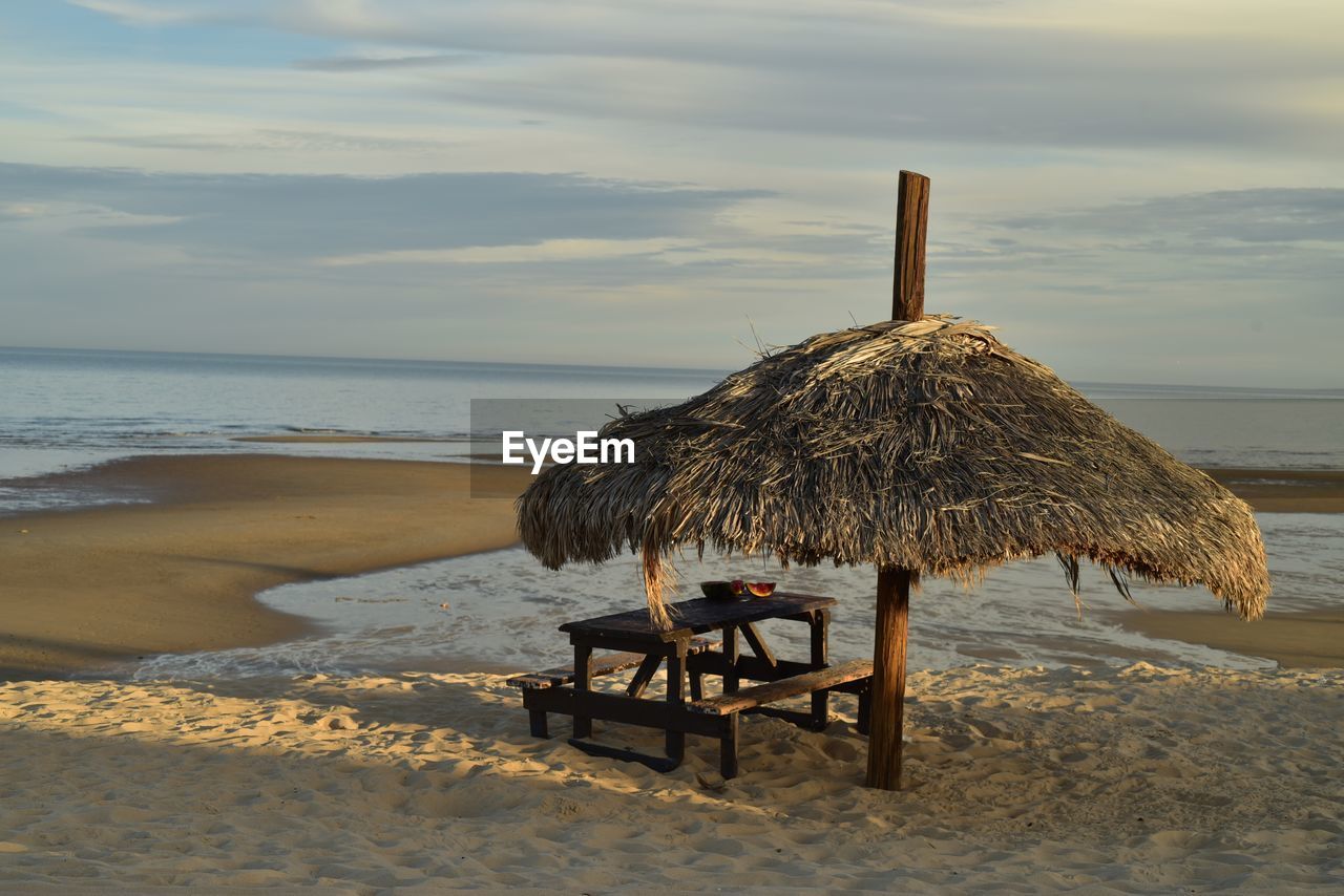  palm thatched beach umbrella  sea of cortez at low tide, in san felipe, baja, mexico