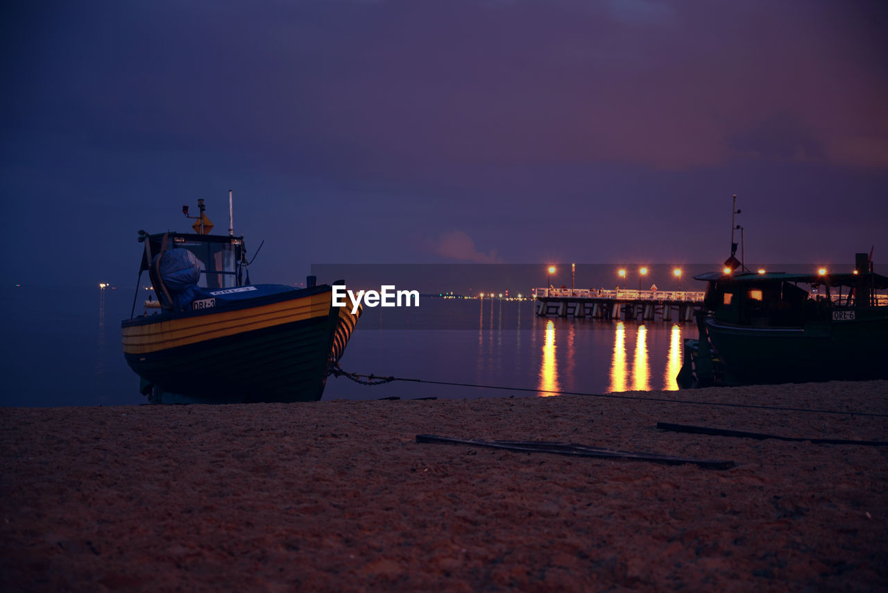 Boat moored in river at harbor against cloudy sky