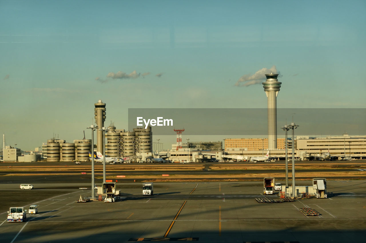 Vehicles on road and a aircraft  against sky in the airport