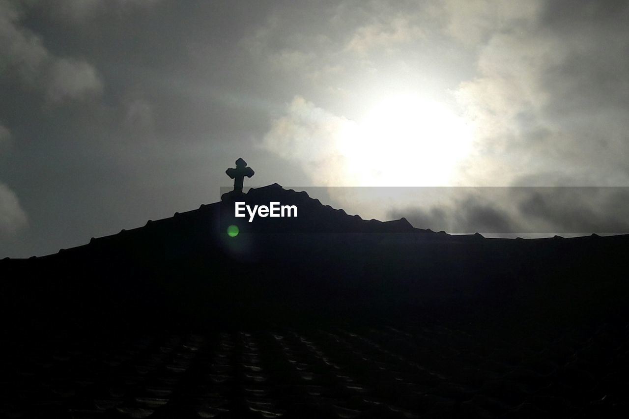 LOW ANGLE VIEW OF SUN SHINING OVER MOUNTAIN