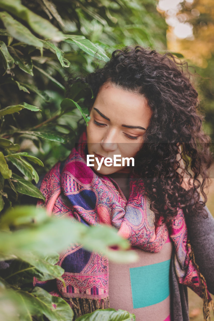 Close-up of young woman by plants