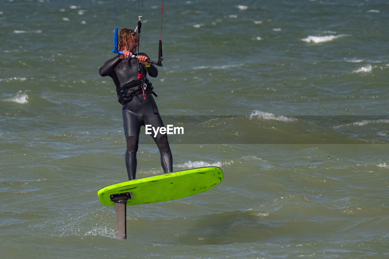 side view of man jumping in sea