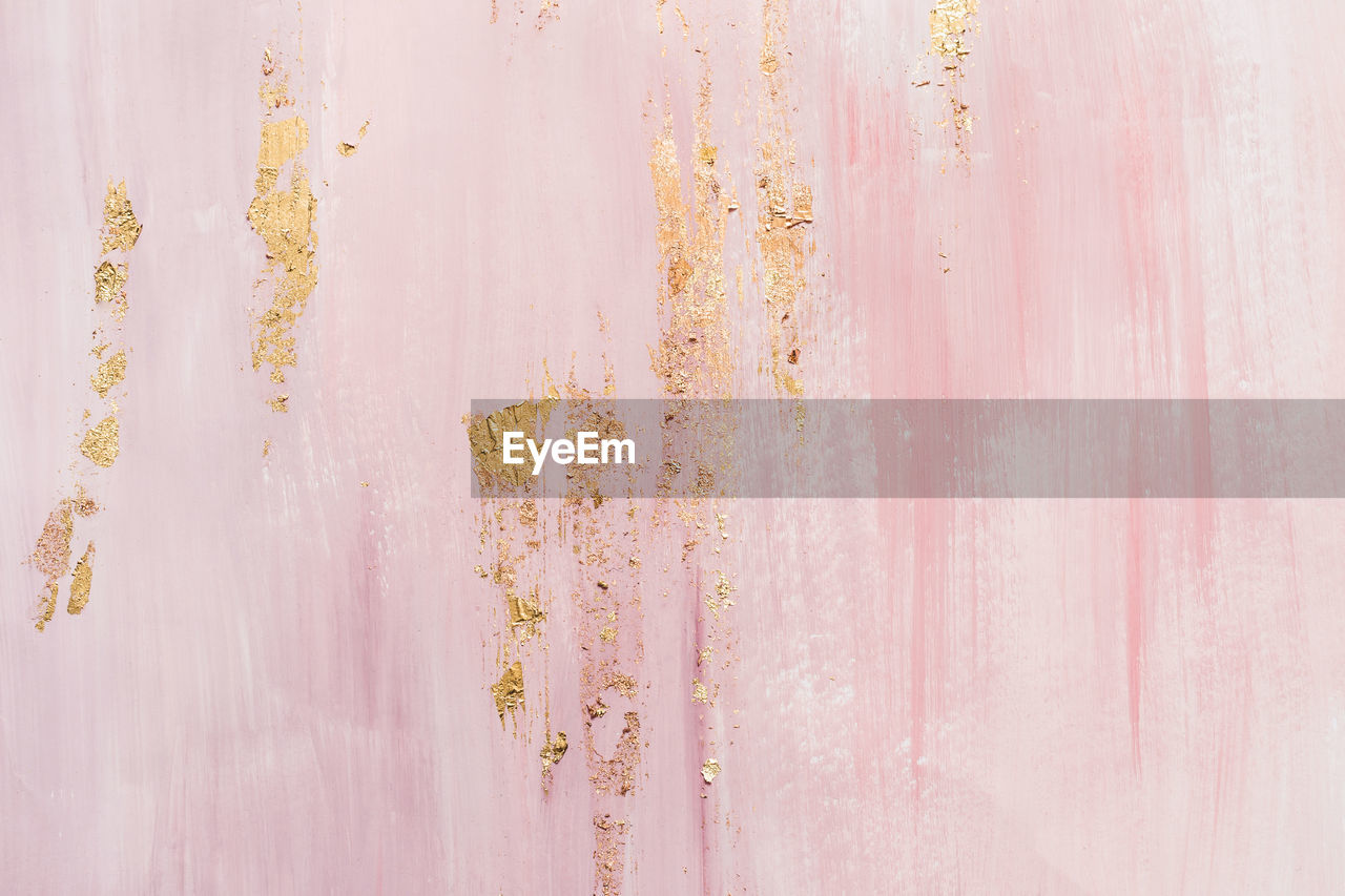 Delicate pink marble background with gold brushstrokes. place for your design.