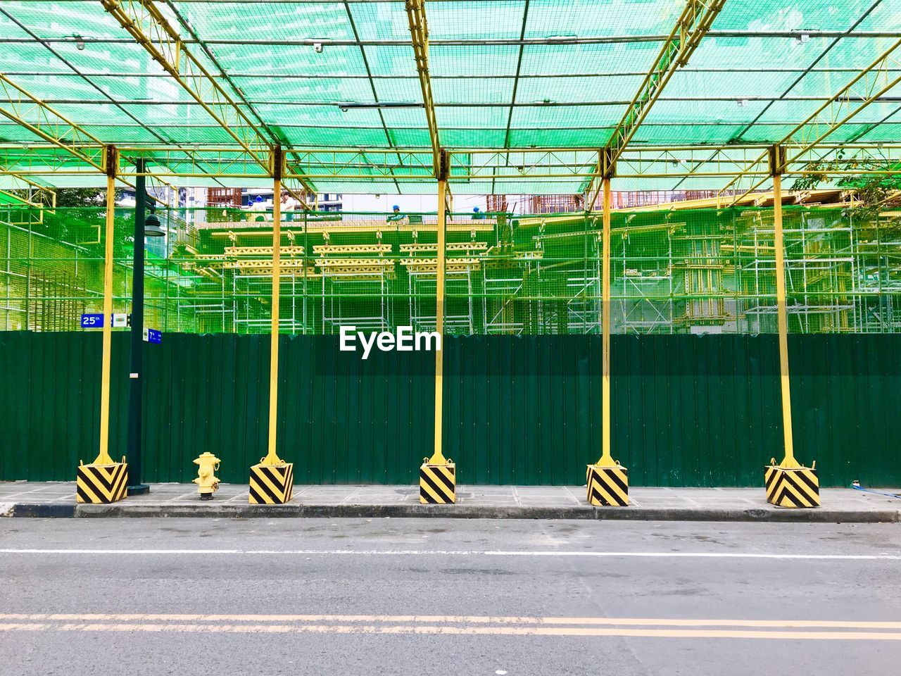 Scaffoldings, safety nets and temporary posts are installed near a construction site in bgc, taguig. 