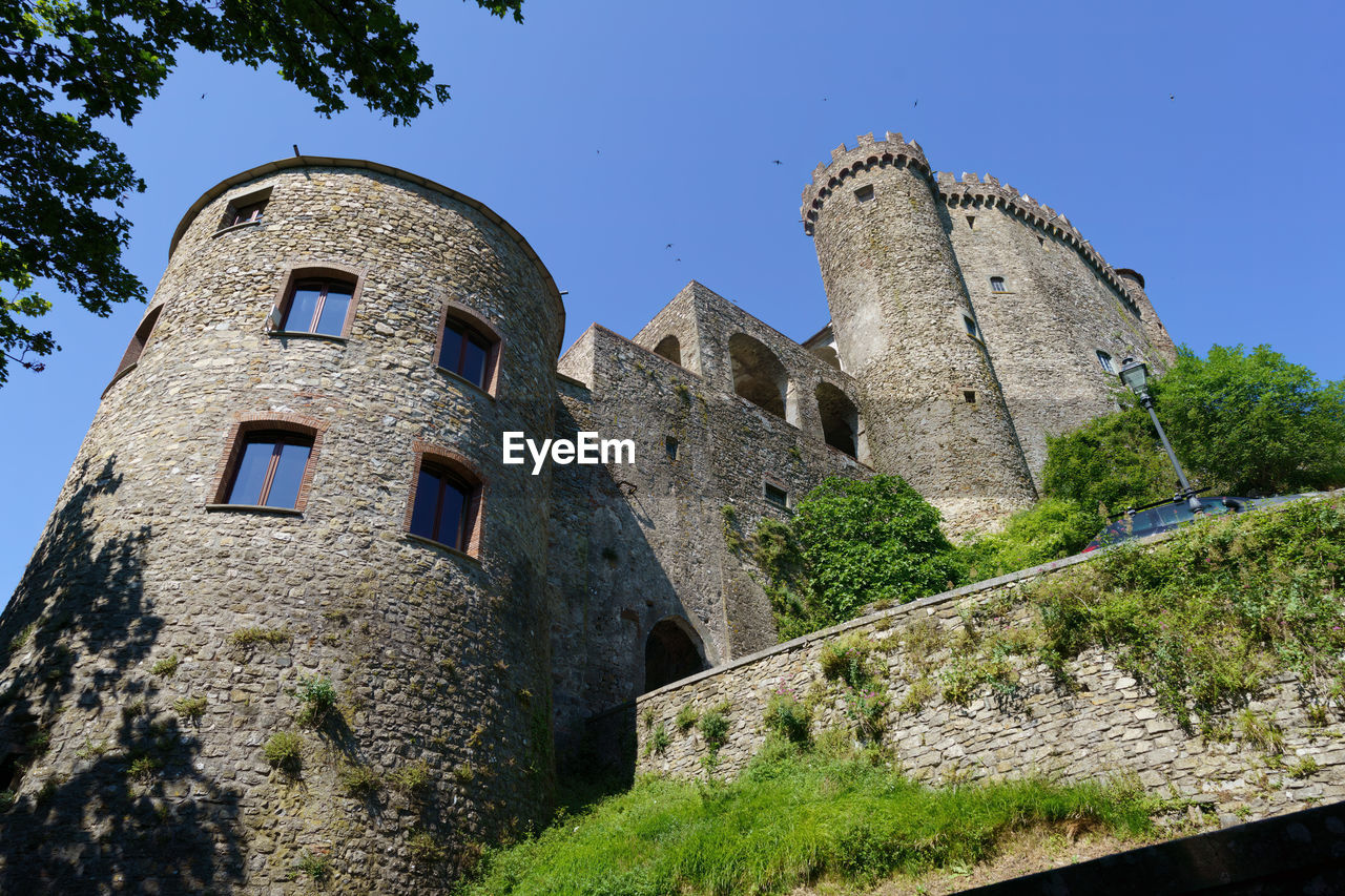 architecture, built structure, history, building exterior, the past, castle, château, building, sky, nature, low angle view, clear sky, plant, travel destinations, tree, old, fort, fortification, no people, wall, medieval, travel, blue, tourism, tower, day, ancient, old ruin, outdoors, fortified wall, sunny, wall - building feature, ruins