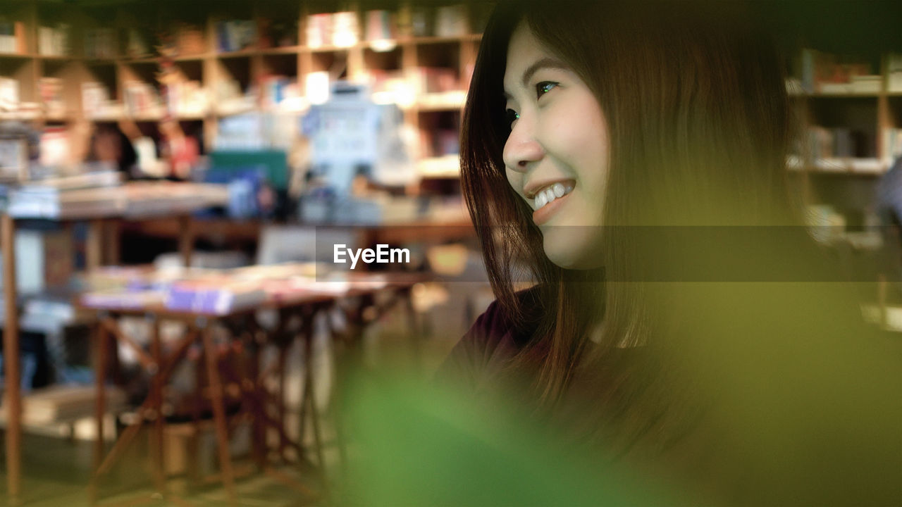 Portrait of smiling young woman looking away outdoors