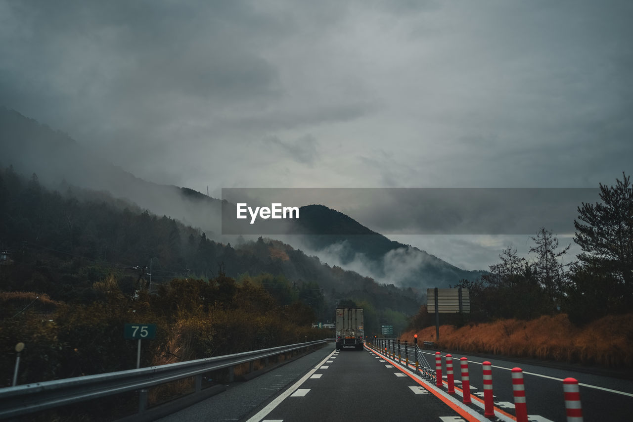 Road leading towards mountains against sky