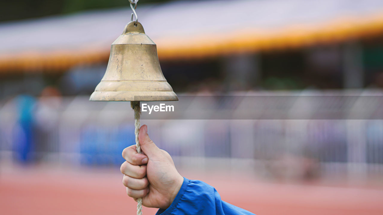 Cropped hand of person ringing bell