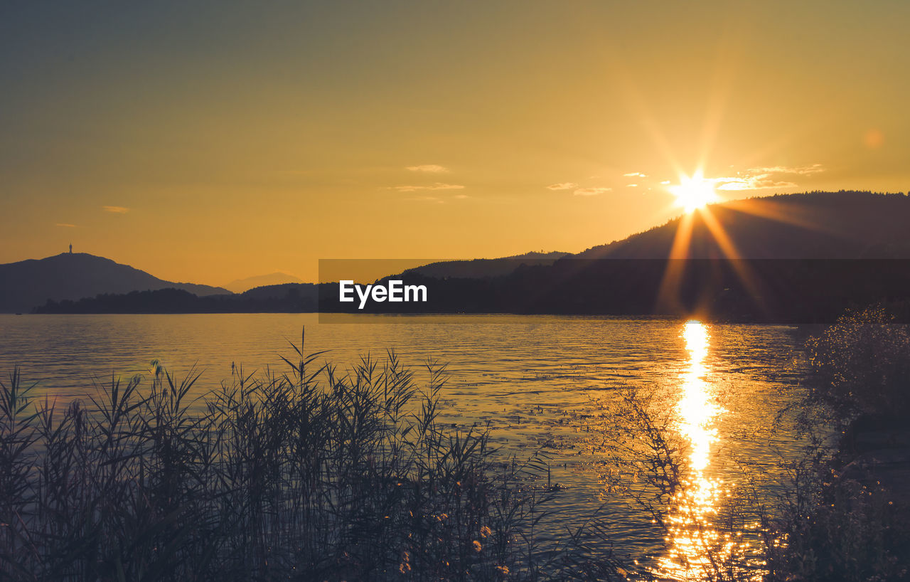 Scenic view of lake against sky during sunset