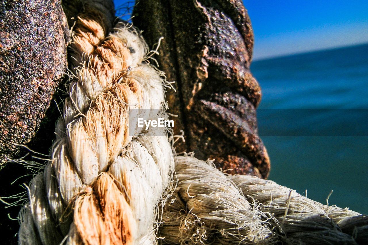 CLOSE-UP OF STACK OF FISHING NET ON SHORE