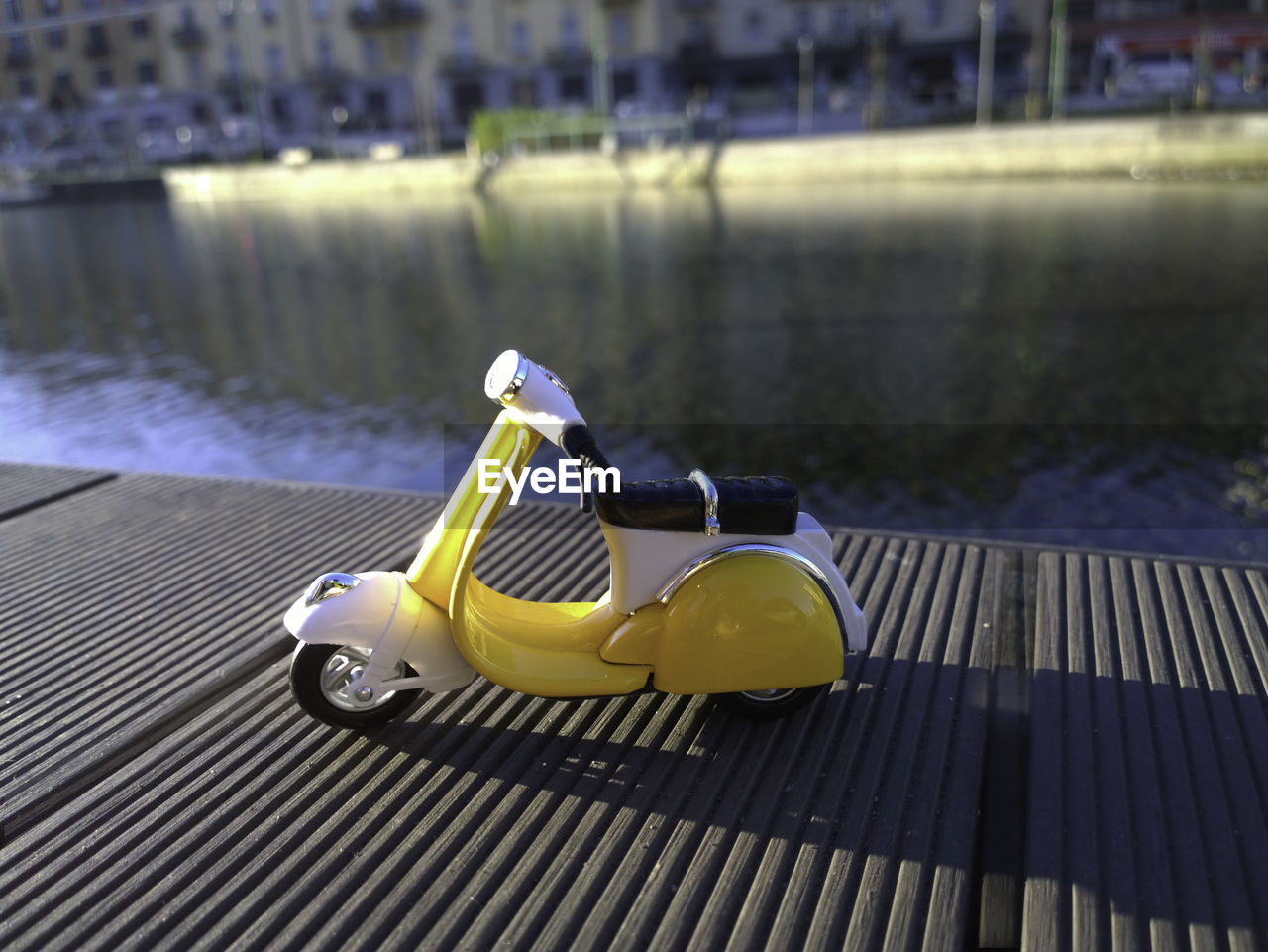Yellow vespa model parcked by navigli in italy