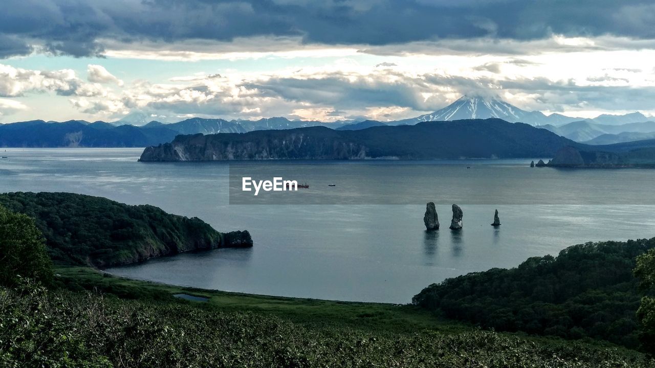 Scenic view of sea and mountains against sky