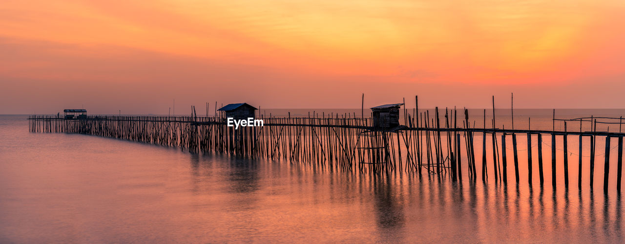 PIER ON SEA AGAINST ORANGE SKY